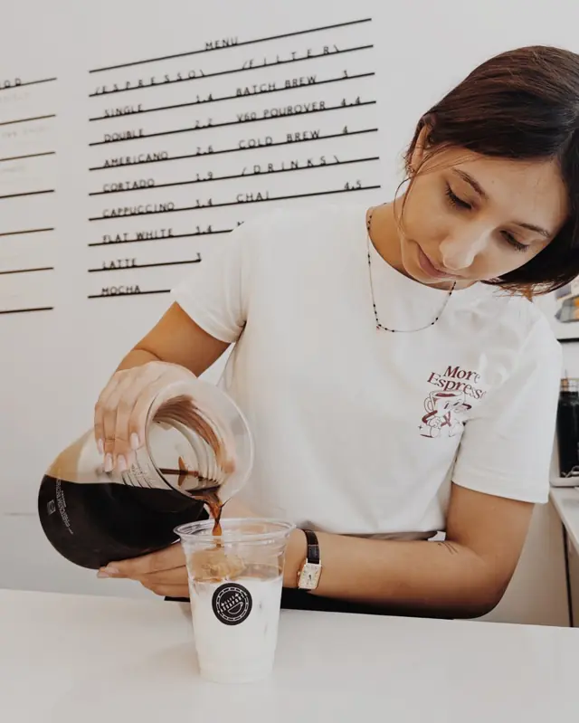 Barista a servir cold brew num latte frio