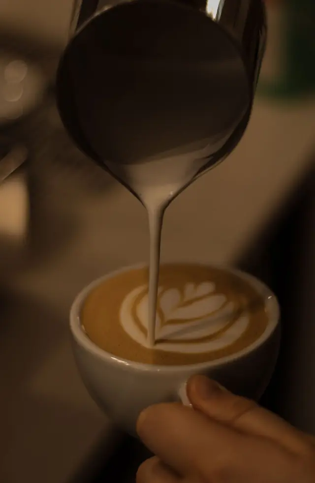 Barista pouring latte art at Café Passaporte in Porto